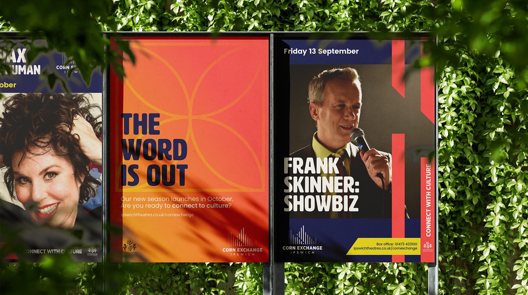 Outdoor posters for Corn Exchange Ipswich promoting upcoming theatre season and events, including Frank Skinner’s show and a “The Word is Out” campaign, framed by leafy green foliage.