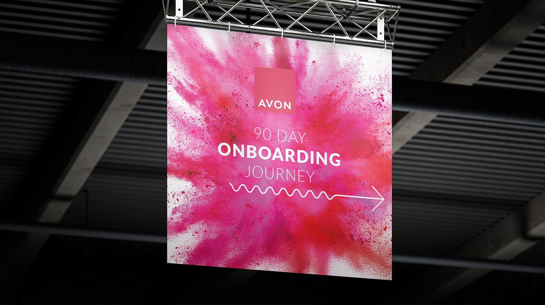 Hanging sign featuring a pink powder explosion design with the Avon logo and text "90 Day Onboarding Journey" with a directional arrow.