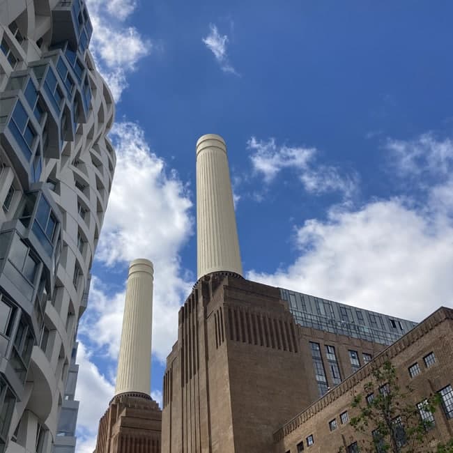 View of Battersea Power Station chimneys alongside modern architecture.